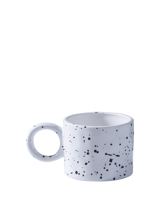 Enjoy your morning cup of coffee or tea in the unique "Bague" mug by TUTU Home. Handmade with love, this ceramic mug features a large ring handle and a stunning ink splash pattern, making it a stylish addition to your morning routine.
