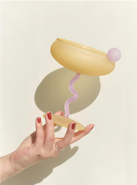 hand with yellow coupe glass