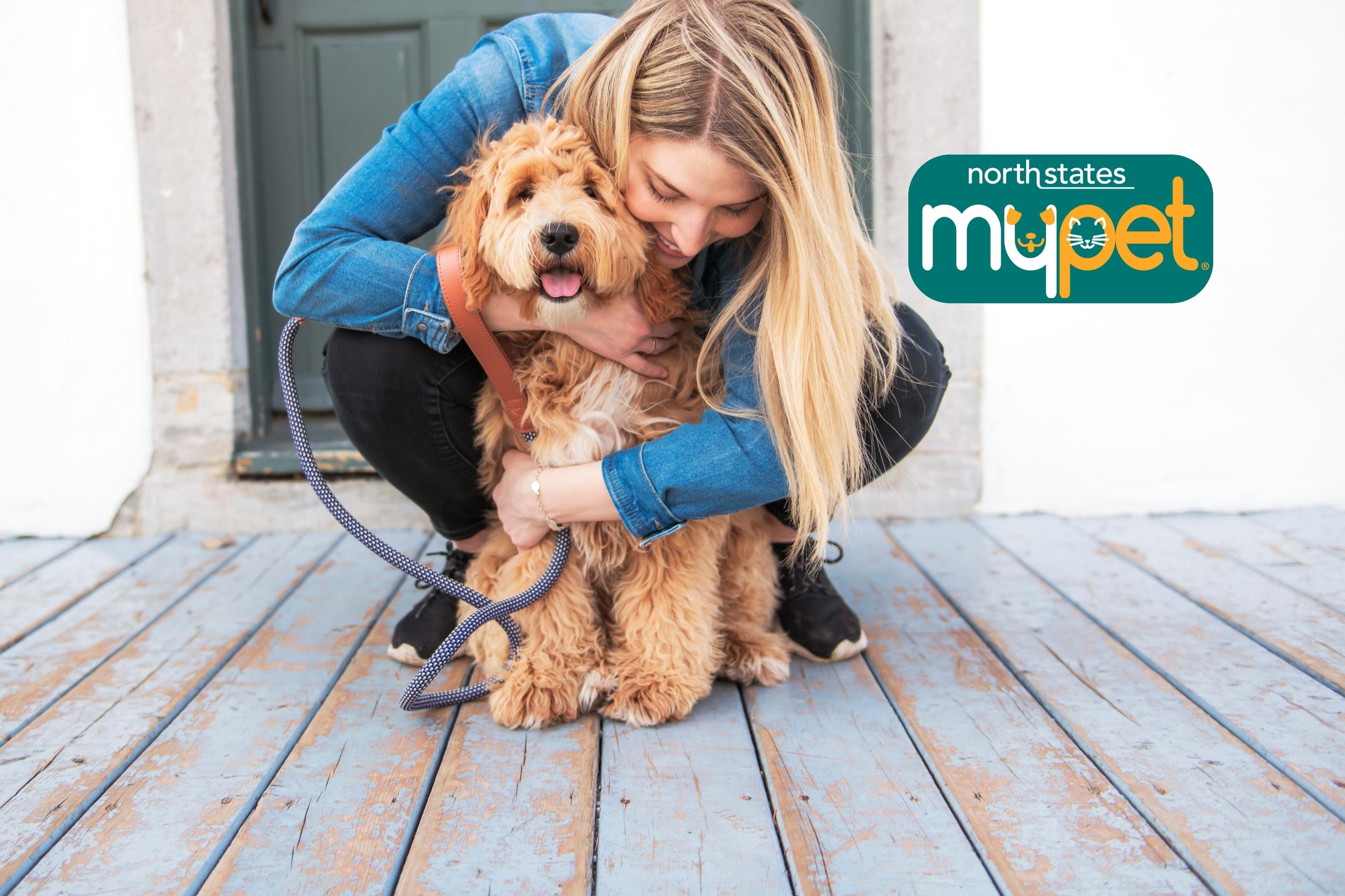 woman hugging a tan curly dog