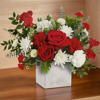 Beautiful Valentines day arrangement with roses and other flowers in a concrete style square vase