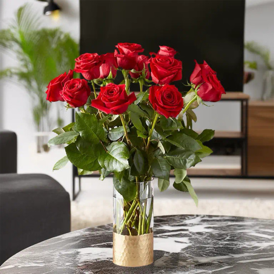 A gorgeous 12 red rose bouquet sitting on black marble table in a living room