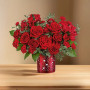 Roses arranged in a cylinder red vase with hearts on it