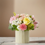 Pastel pink rose bouquet with yellow roses, white cushion mums and alstroemeria in a modern fluted ceramic vase on marble table