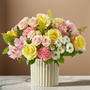 Pastel pink rose bouquet with yellow roses, white cushion mums and alstroemeria in a modern fluted ceramic vase on marble table
