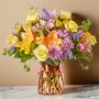 Premium colorful mix of spring flowers in a pink cinch vase