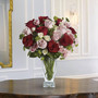 A beautiful mix of red and minx roses sitting on a wooden table