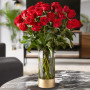 A gorgeous 36 red rose bouquet sitting on black marble table in a living room