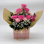 Pink roses and carnations designed in a pink purse container