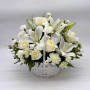 Premium All-white sympathy flower basket with lilies, roses, and carnations arranged in a white woven basket for funeral or condolence delivery by Flower Den Florist