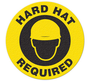 A photograph of an anti-slip safety floor markers, reading hard hat required.
