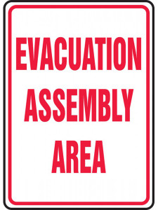 White sign with red border and red lettering of EVACUATION ASSEMBLY AREA.
