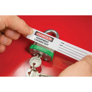 A photograph of over-laminate label 07251 reading "Danger.  Equipment Locked Out" being placed on a metal padlock (not included).
