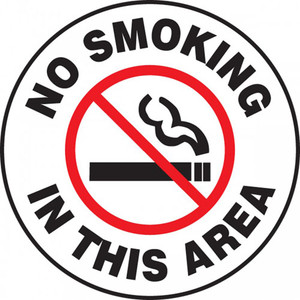 A photograph of a black and white 11258 pavement print sign, reading no smoking in this area, with a no smoking graphic.