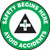 This green, white, and black sign features the text "Safety Begins Here Avoid Accidents". In the center is an ANSI-style safety cross in green and black. Use to promote awareness of safety and accidents.
