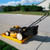 A photograph of an unfolded 20 gallon capacity Justrite Folding Utility Tray holding a lawn mower (not included).