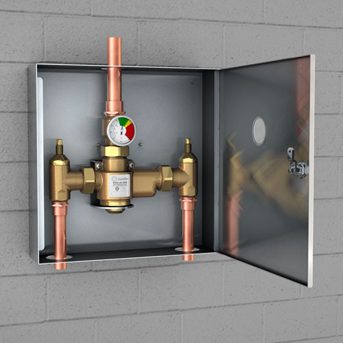 A photo of the G6042 TMV in a surface-mounted cabinet installed on a cinderblock wall.