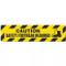 Photograph of an anti-slip floor safety sign reading "Caution Safety Footwear required" in black on a yellow background.  Includes a graphic of a a yellow and black boot.