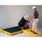 A photograph of a drum being put in place with use of ramp.