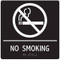 A photograph of a white on black 03506 ADA braille tactile sign, reading no smoking with cigarette prohibition graphic.