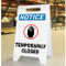A photograph a white A-Frame Standing Floor sign, standing upright. The front face has an OSHA NOTICE header, a black hand icon with red circle, and the words TEMPORARILY CLOSED.
