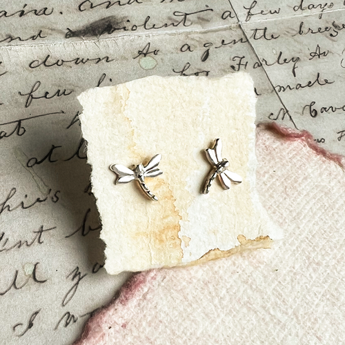 Sterling silver dragonfly stud earrings displayed on a cream card
