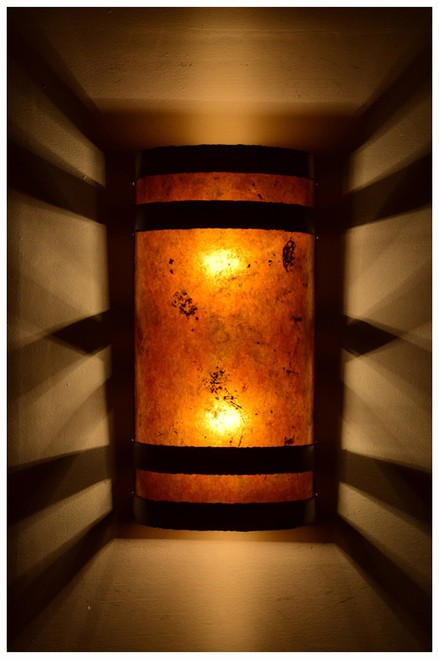 Dark antique copper banded wall light with amber mica at night