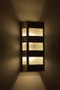 Slat Wall Sconce - Antique Copper finish with Frosted Glass lighted on wall.