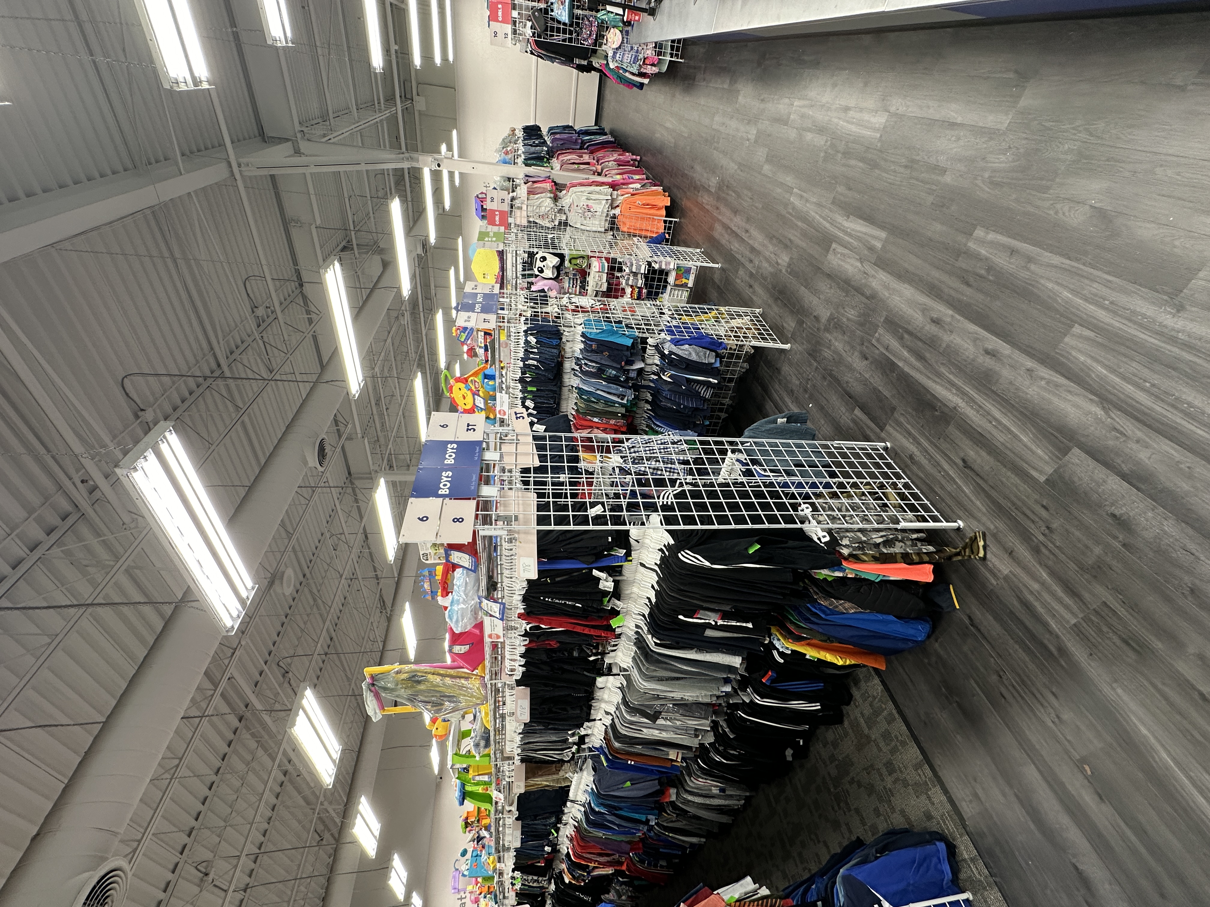 a photo of the interior of the store, showing racks of clothes and toys.