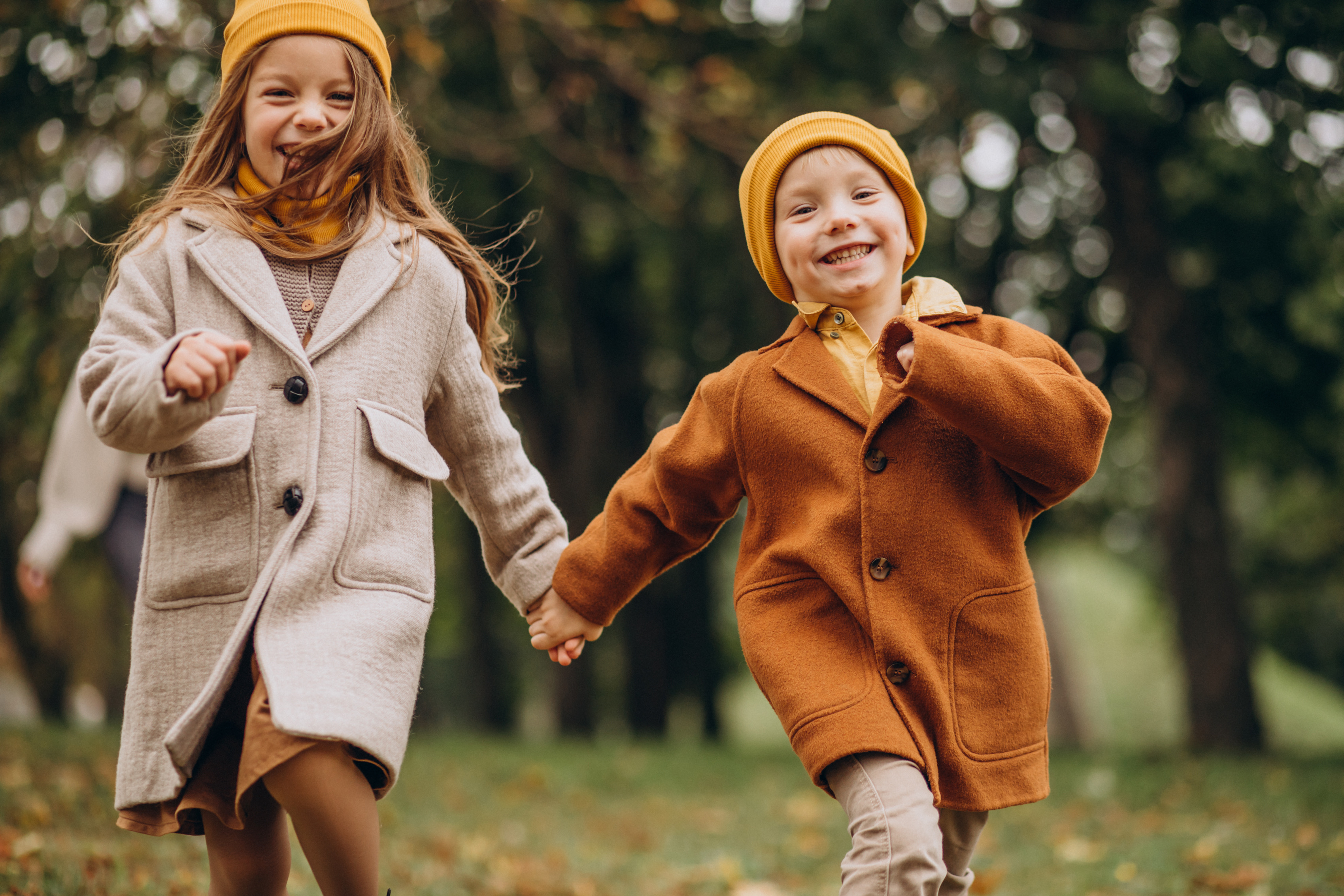 Kids dressed in warm clothing and playing in fall weather