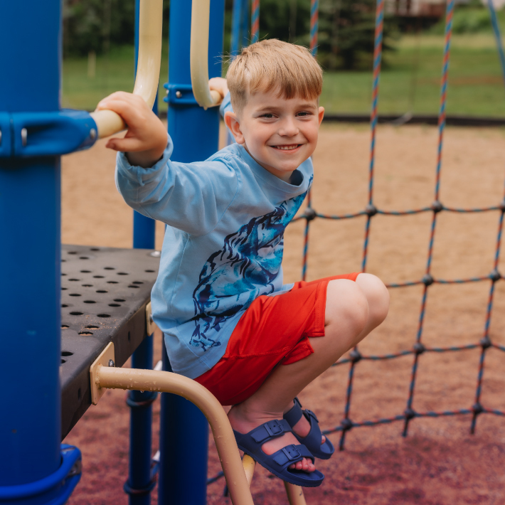 little boy playing on playground