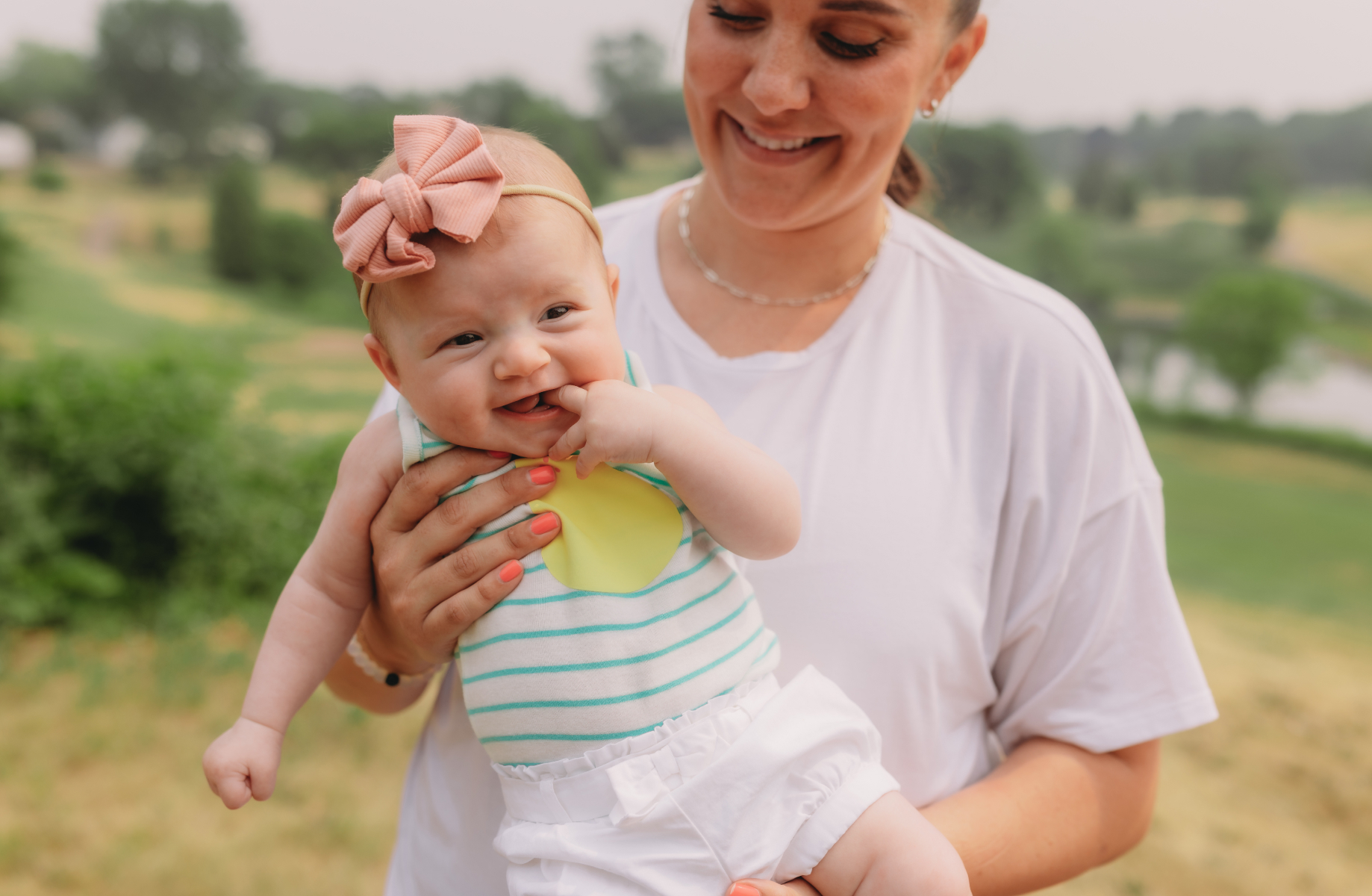 A joyful woman cradling a baby, both smiling