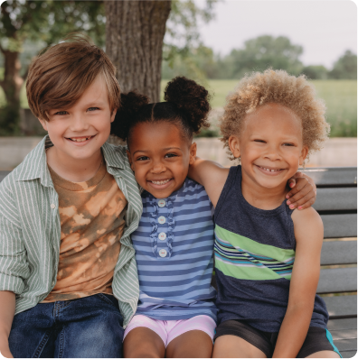 three children sitting outside