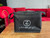 A black rectangular insulated bag with a zip opening, and embellished with a white Zontes Footstep logo on the front, on a coffee table with a red sofa in the background.