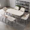 Bexley table with the included six beige armchairs in a room setting. Shelving, rug, plants and decor are not included.