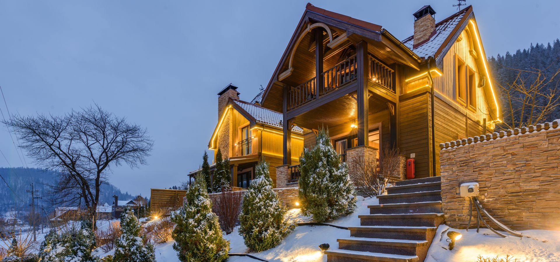 Snow-covered vacation chalet with warm exterior lighting