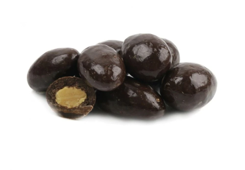 Pile of rich dark chocolate covered almonds, glossy dark brown, crunchy, delicious USA-made candy.