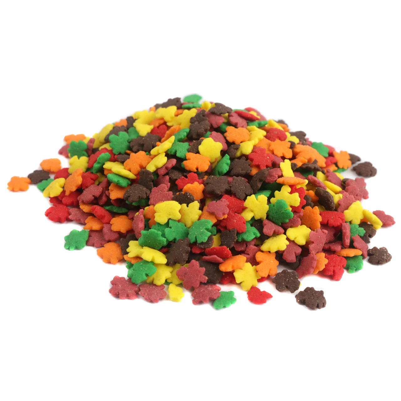 Colorful autumn leaf candy sprinkles scattered on a white surface for fall baking.