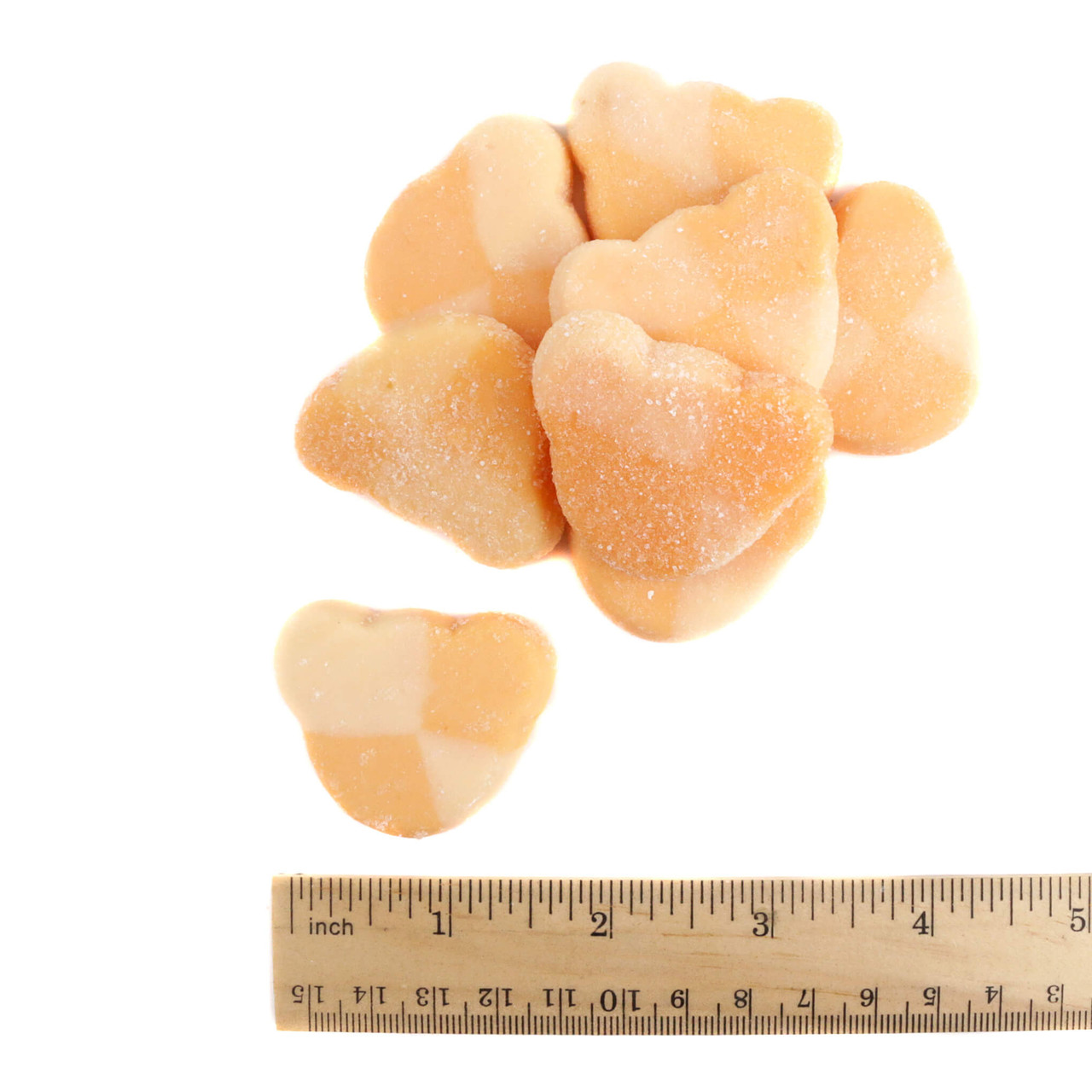 sweet and sour yellow mango gummy bear coated in fine sugar with a ruler showing size