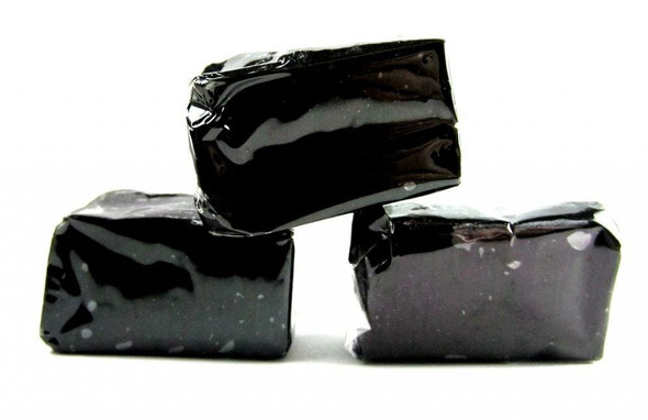 Black Licorice Caramels, individually wrapped in clear cellophane, showing soft texture. Approx 40 pieces per pound.