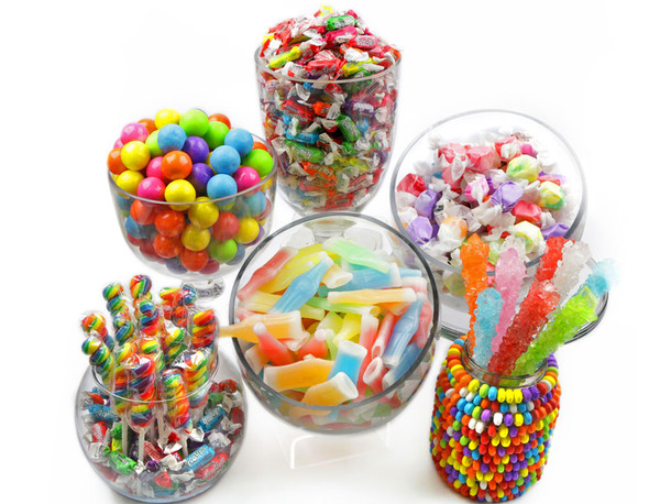 Bright rainbow candy buffet with colorful rock candy, twisted lollipops, gumballs, Tootsie Frooties, necklaces, taffy.