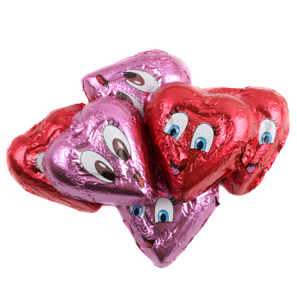 Multiple Valentine chocolate hearts with expressive faces, individually wrapped in bright red and pink foils.