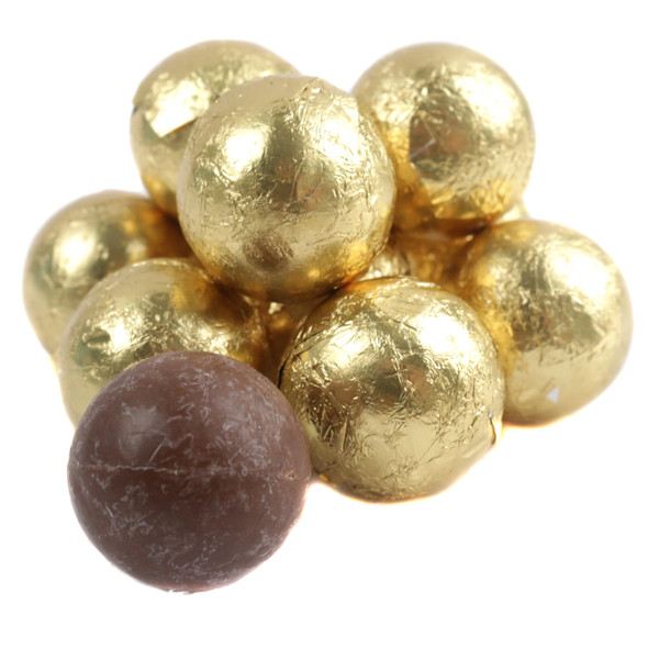 Glistening gold-wrapped round milk chocolates stacked in a festive holiday arrangement.