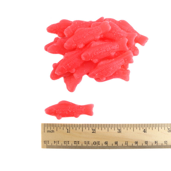 Many bright red sour gummy fish candies with a white sugar coating.