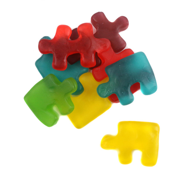 Colorful red, green, blue, yellow, purple gummy puzzle pieces. Fruit flavors: cherry, blueberry, green apple, lemon, grape.