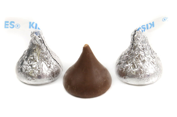 Hershey Kisses, 25lb bulk, individually wrapped silver foil milk chocolate candies, classic tear-drop shape.
