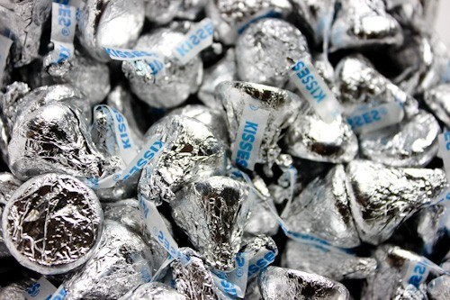 Bulk 25lb Hershey Kisses, thousands of individually wrapped chocolates in classic silver foil, iconic teardrop shape.