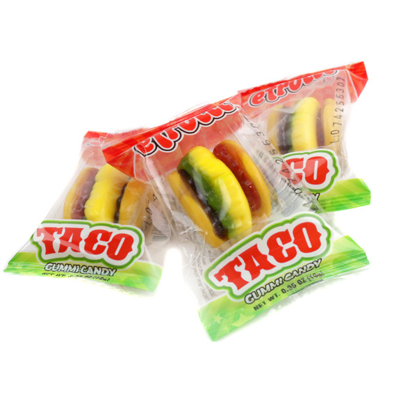 Piled high, 16 pounds of colorful Efrutti mini gummy tacos, shaped like real tacos with green, red, yellow details. Fruity candy.