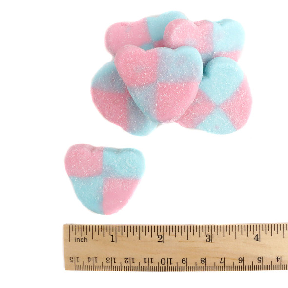 A detailed close-up of blue and red bear-shaped gummies showing the crystalline sour sugar coating