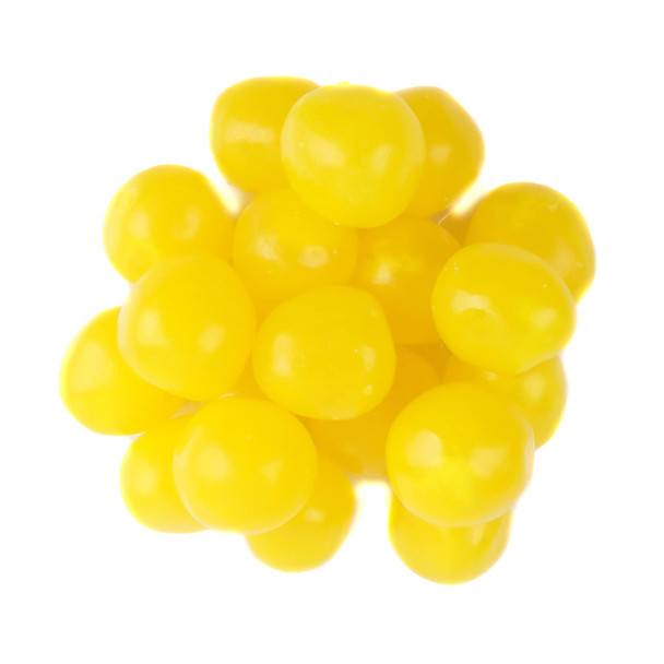 Bright yellow lemon chewy sour balls, hard candy shell, tart lemon center. Bulk pile of sour candy.