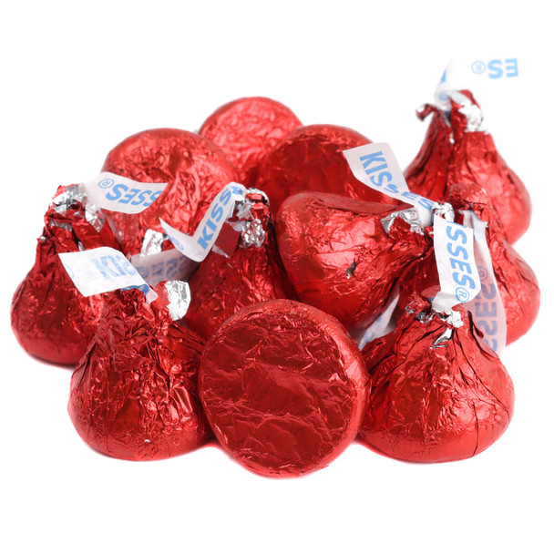 Red Hershey Kisses, iconic bite-sized milk chocolate candy, wrapped in shiny red foil. Approximately 100 per pound.